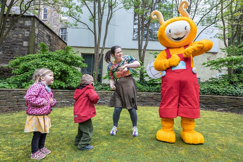 Bookbug's Big Shoogle - photo of Bookbug and children dancing in a garden